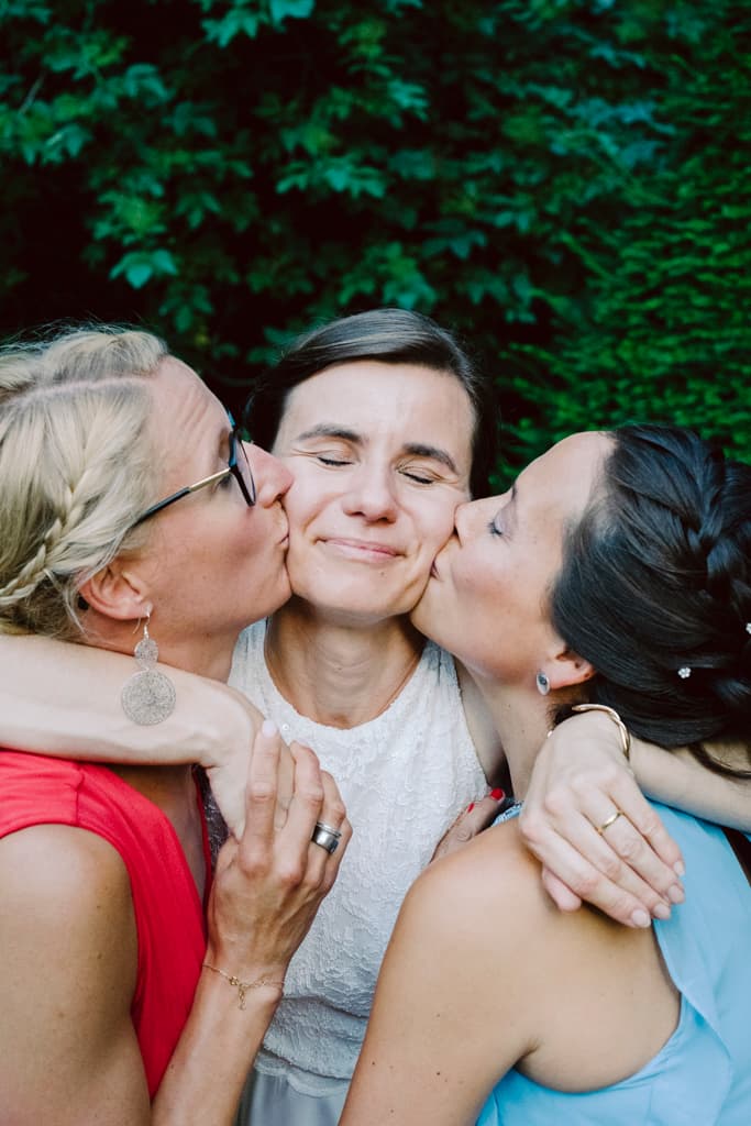 bride kissed by two bridemaids