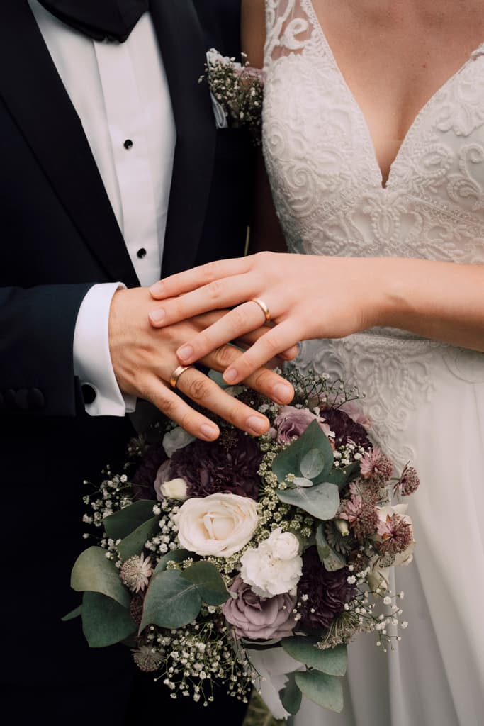 close up shot of wedding couple's hands with their wedding rings