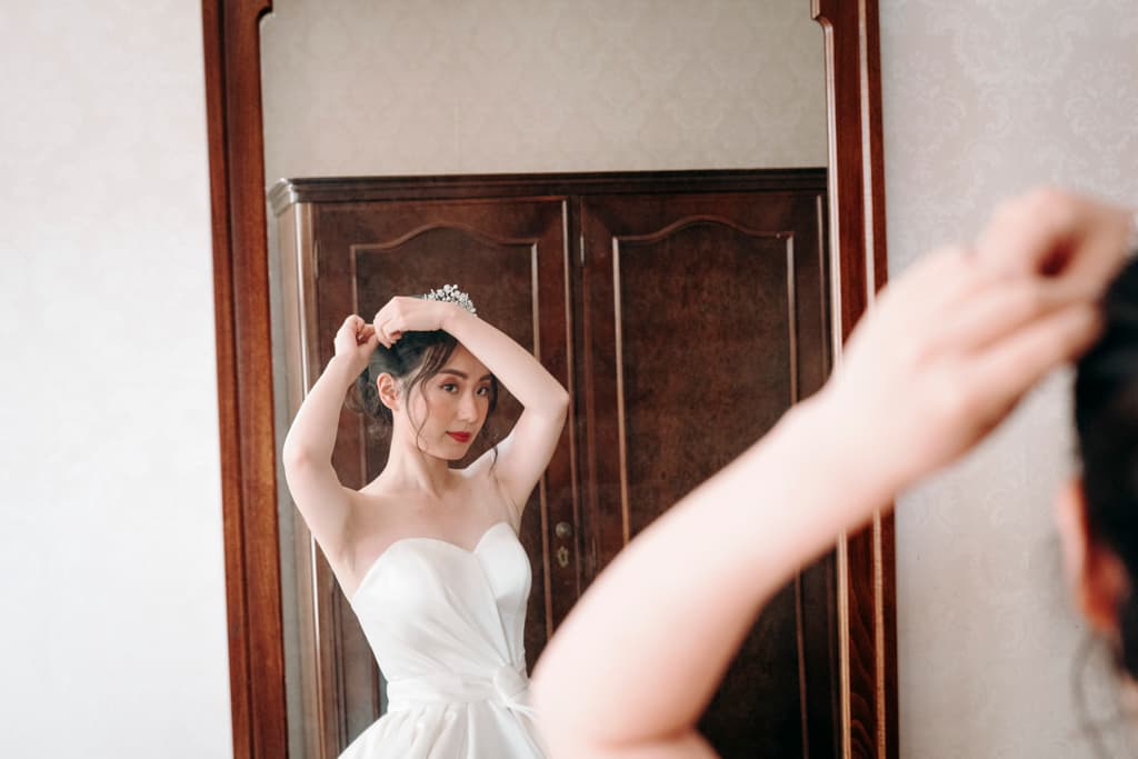 Bride preparing for the wedding ceremony in front of a mirror