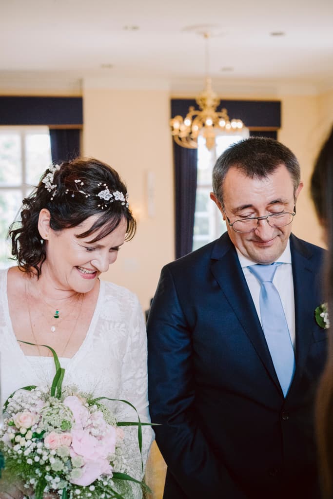 wedding couple during the wedding ceremony listening to a speech in the festive room of the castle Schloss Lübbenau