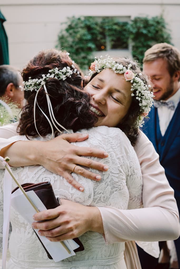 daughter of the bride hugging the bride