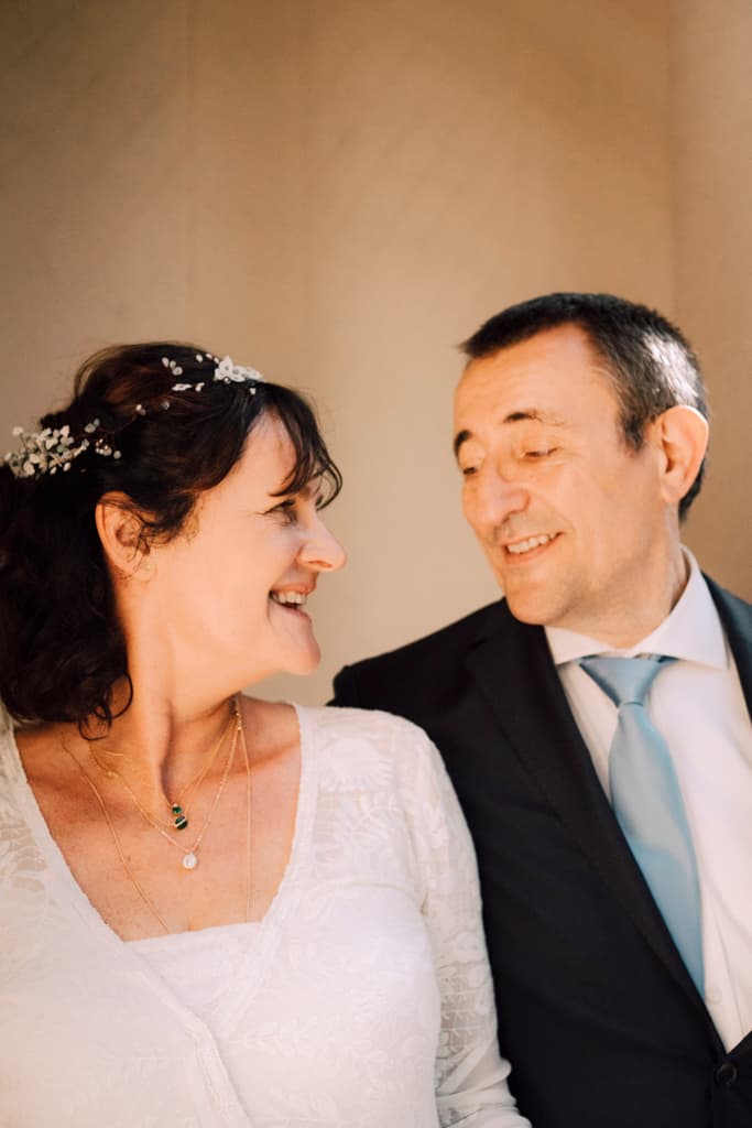 Bride and groom peacefully smiling at each other in front of a wall of Schloss Lübbenau in Spreewald