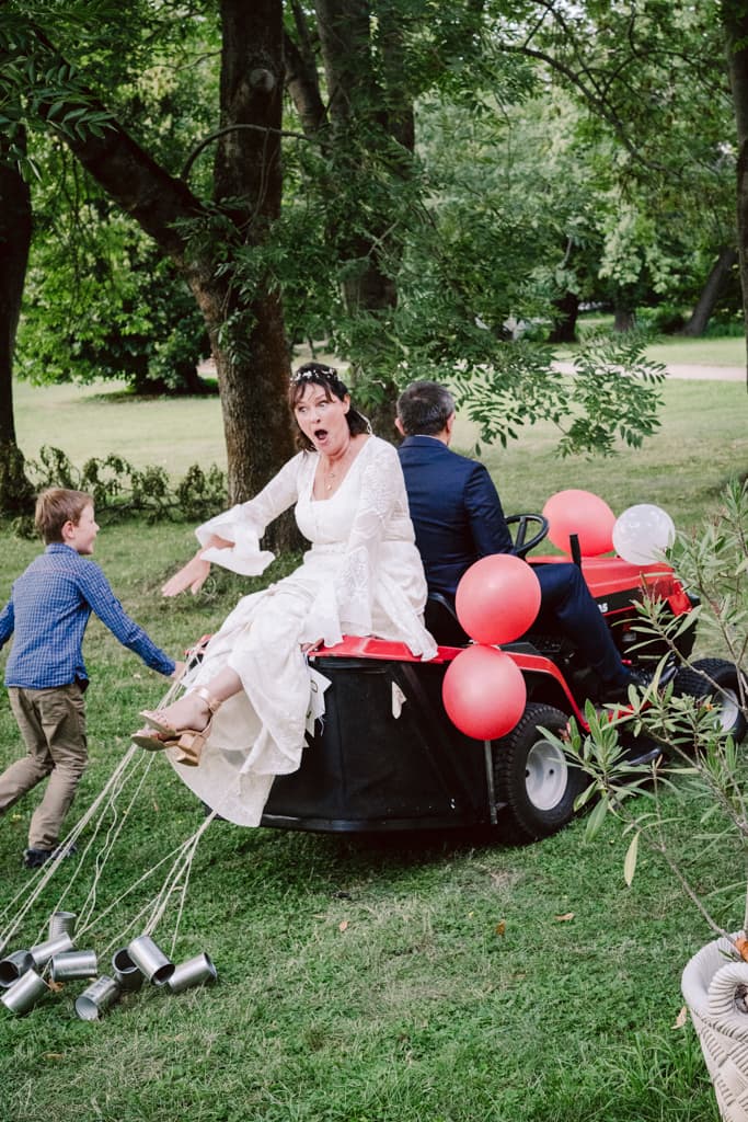 Bride and groom sitting on a lawnmover in the park of Schloss Lübbenau in Spreewald by Berlin