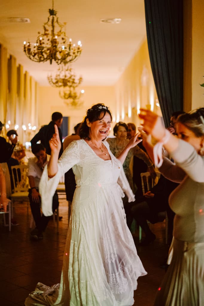 Bride dancing and smiling at the wedding party in Schloss Lübbenau in Spreewald